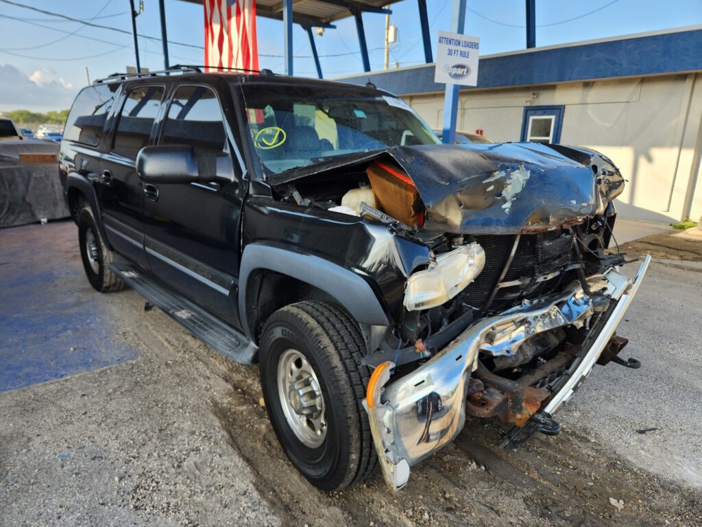 Black Chevrolet Suburban with severe front-end collision damage, evaluated for total loss appraisal in Fort Lauderdale, Florida